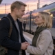 Para żegna się na peronie, mężczyzna z torbą podróżną trzyma partnerkę za ręce